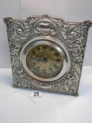 A good quality embossed silver plated mantel clock in good working order (8" wide x 8" high).