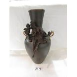 A bronze vase featuring figures of a lady and cherub.