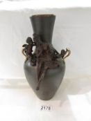 A bronze vase featuring figures of a lady and cherub.