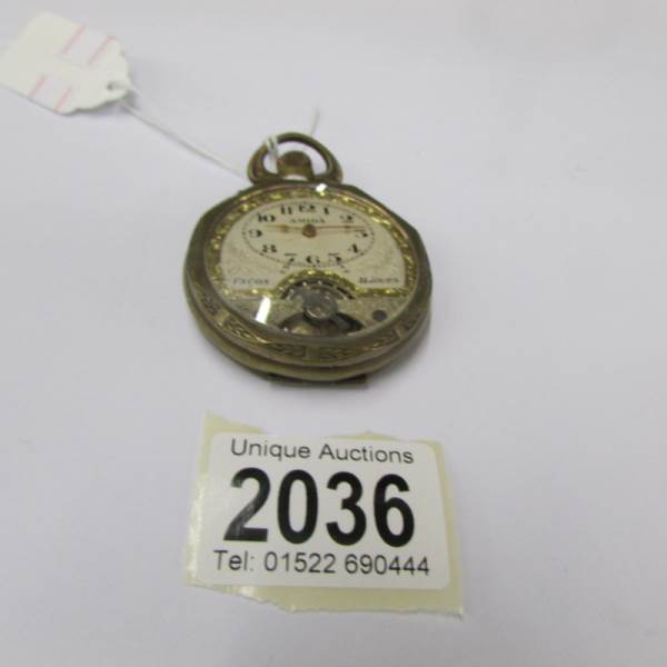 An Amida 8 day brass pocket watch.