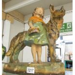 A plaster figure of a girl with Alsation dog.