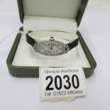 An Art Deco wristwatch in platinum set with diamonds, with original black silk strap,