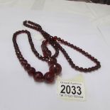 A long bakelite cherry coloured necklace.