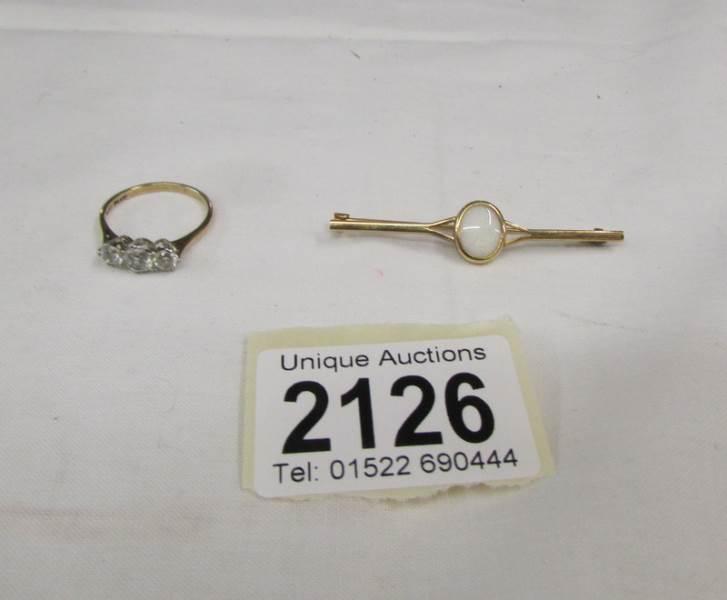 A 9ct gold ring set 3 clear stones, size O and a 9ct gold bar brooch.