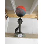 A heavy bronze table lamp in the form of a cobra on marble base with coloured glass globe shade.