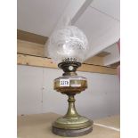 A Victorian oil lamp complete with chimney and original acid etched shade.