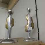 A pair of mismatched brutalist aluminium and brass candlesticks by David Marshall.