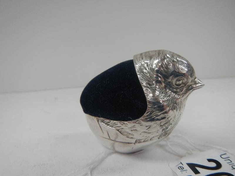 A hallmarked silver pin cushion in the form of a bird