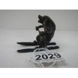 An early painted bronze of a dog on skis 2 inches high