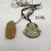 A carved stone Buddha pendant and a jade pendant.