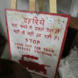 A painted metal sign for railway crossing in Indian and English.