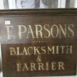 A wooden sign for F. Parsons, Blacksmith & Farrier.