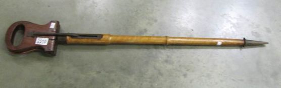 A vintage shooting stick with wooden seat.