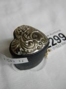 A heart shaped silver topped ring box.