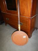 A Victorian copper warming pan.