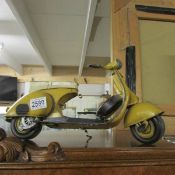 A tin model of a motor scooter.