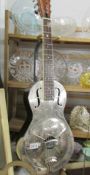 A Republic Resonator Guitar featuring chrome body and with hard case.