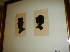 A framed and glazed pair of late 19th century watercolour silhouettes of male and female,