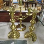A pair of brass candlesticks and a brass candelabra.