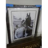 A framed and glazed horse racing print featuring Bob Champion.