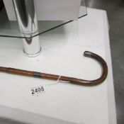 A bamboo walking cane with silver tip.