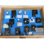 A display case containing 6 silver rings, all with certificates, and 10 silver pendants.