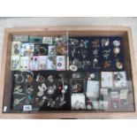A display case containing in excess of 100 pieces of mainly silver jewellery including earrings,