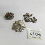 A silver dragon pendant and 2 silver brooches one set with coral stone.