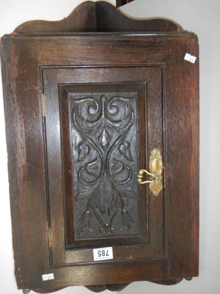 An early 20th century carved oak corner cupboard, 30" tall.
