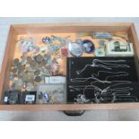 A display case containing assorted coins, silver pendants and other jewellery etc.