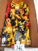 A box containing various die cast dumper truck and truck models.