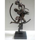 An art deco style figure of a dancing lady with hoop in back ground in a bronzed finish.