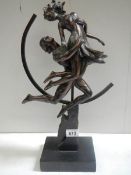 An art deco style figure of a dancing lady with hoop in back ground in a bronzed finish.