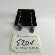 A pair of amethyst and diamond drop earrings.