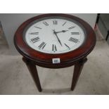 An occasional table with clock inset to top.