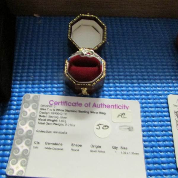 A display case containing 6 silver rings, all with certificates, and 10 silver pendants. - Image 10 of 23