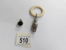 An early 20th century childs silver rattle with teething ring together with a silver fob dated