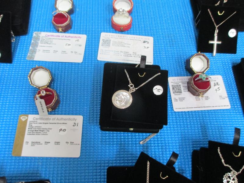 A display case containing 6 silver rings, all with certificates, and 10 silver pendants. - Image 13 of 23