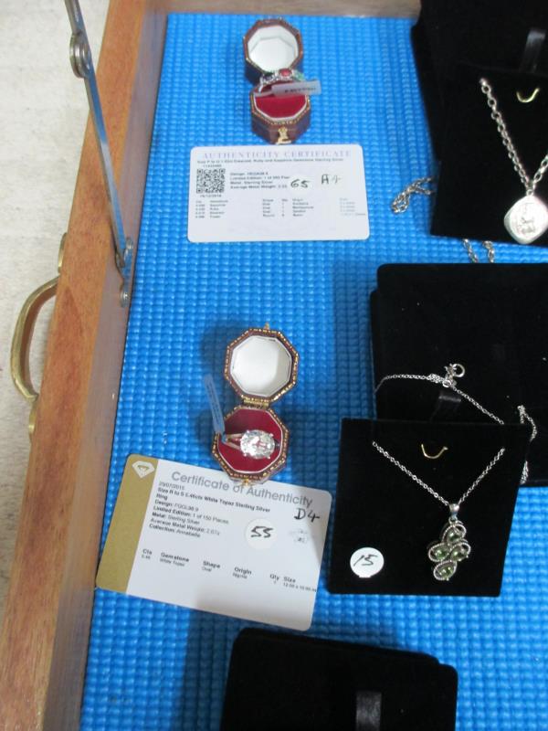 A display case containing 6 silver rings, all with certificates, and 10 silver pendants. - Image 15 of 23