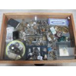 A display case containing assorted coins, bank notes, jewellery, powder compacts etc.