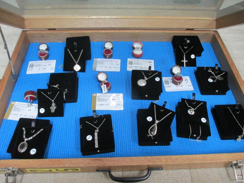 A display case containing 6 silver rings, all with certificates, and 10 silver pendants. - Image 3 of 23