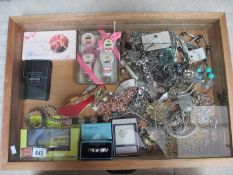 A display case containing a mixed lot of costume jewellery, boxed toiletries,