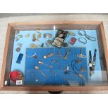 A display case of miscellaneous items including watches, jewellery, Wade Whimsies etc.
