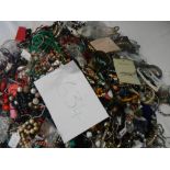 A very large collection of unsorted costume jewellery (crate not included)