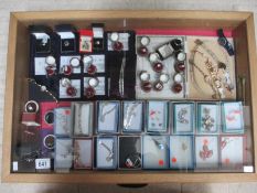 A display case of approximately 40 pieces of mainly silver jewellery including pendants, rings,