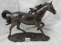 A bronzed resin horse, 16" long x 12" tall.