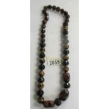 A long necklace of gemstone beads (Tigers eye).