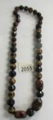 A long necklace of gemstone beads (Tigers eye).