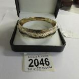 A circa 1970/80's, 9ct gold on a metal engraved bangle.
