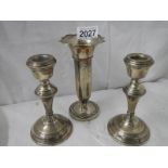A pair of silver candlesticks and a silver spill vase.